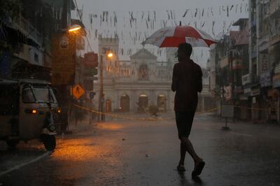 A man crosses a street during heavy rain near the security cordon surrounding St. Anthony's Shrine, days after a string of suicide bomb attacks on churches and luxury hotels across the island on Easter Sunday, in Colombo, Sri Lanka April 25, 2019. REUTERS/Thomas Peter