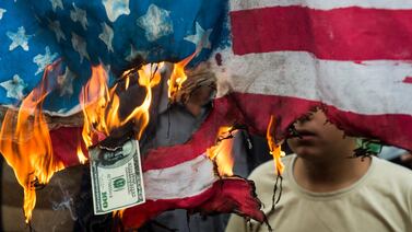 Protesters in Tehran burn an American flag and a hundred dollar bill during a demonstration on the anniversary of the 1979 US embassy seizure. Bloomberg