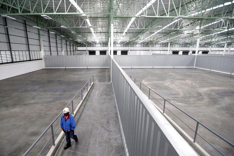 A worker walks in a recently built empty distribution warehouse in Udon Thani. Jorge Silva / Reuters