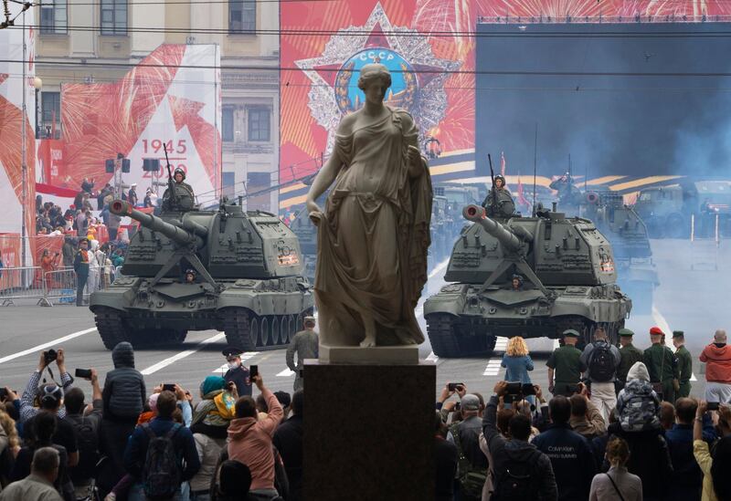 People take photos of a military parade at Dvortsovaya Square in St.Petersburg, Russia. AP