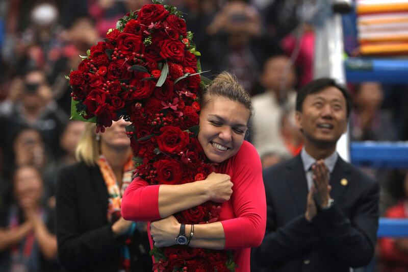 Simona Halep of Romania hugs a floral bouquet in the shape of the number one after beating Jelena Ostapenko of Latvia in their women's singles semifinal in the China Open tennis tournament at the Diamond Court in Beijing, Saturday, Oct. 7, 2017. Halep achieved the women's world #1 ranking with the victory. (AP Photo/Mark Schiefelbein)