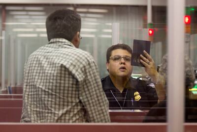 A Customs and Border Protection officer checks the passportvisitor to the United States. AP