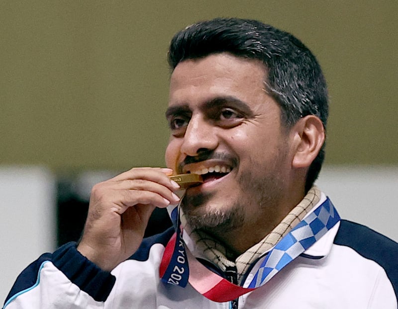 Javad Foroughi of Iran celebrates on the podium after winning the Men's 10m Air Pistol.