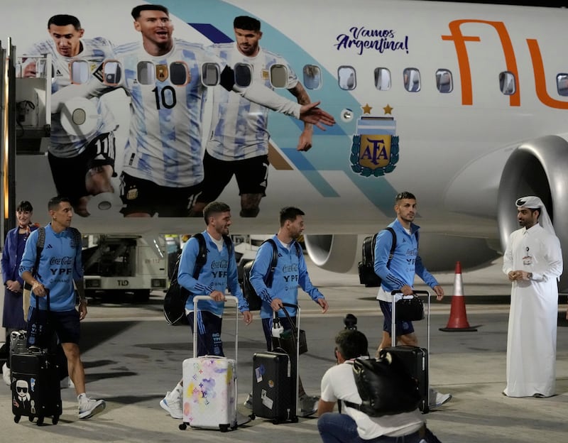 Angel Di Maria, left, and Lionel Messi, second right, of Argentina arrive with teammates at Hamad International Airport in Doha. AP Photo 
