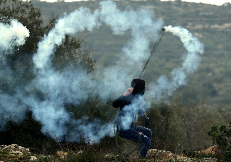 A Palestinian protester hurls a tear gas canister towards Israeli security forces following a demonstration against settlements in the village of Beita in the occupied West Bank. AFP