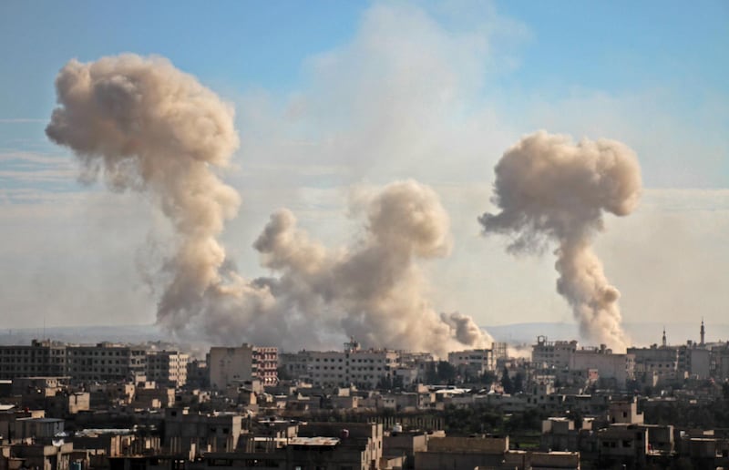 Smoke rises from buildings following bombardment on the village of Mesraba in the rebel-held besieged Eastern Ghouta region on the outskirts of the capital Damascus, on February 19, 2018. Hamza Al-Ajweh / AFP