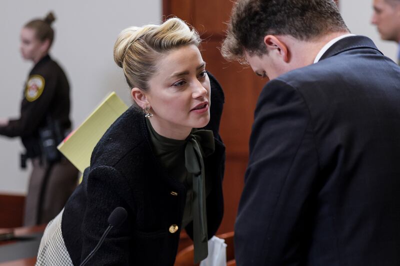 Heard speaks to her legal team as she leaves the courtroom for a break. AP