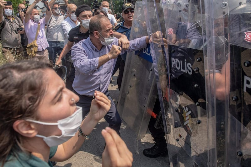 Republican People's Party deputy leader Tuma Celik clashes with Turkish riot police during a March for Democracy rally after three opposition MPs were revoked and sent to prison at Silivri, in Istanbul.  AFP