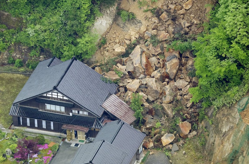 The Suzu earthquake triggered a landslide, swamping houses and blocking roads to emergency services. AP