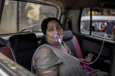 FILE - In this April 24, 2021, file photo, a COVID-19 patient sits in a car and breathes with the help of oxygen provided by a Gurdwara, a Sikh house of worship, in New Delhi, India. Despite clear signs that India was being swamped by another surge of coronavirus infections, Prime Minister Narendra Modi refused to cancel campaign rallies, a major Hindu festival and cricket matches with spectators. The crisis has badly dented Modiâ€™s carefully cultivated image as an able technocrat.  (AP Photo/Altaf Qadri, File)