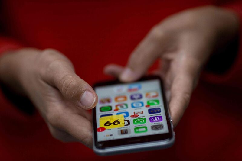 A woman holds a smartphone showing the Brazilian App for ridesharing 99 Taxi in Rio de Janeiro, Brazil, on January 4, 2018.
Chinese ride-hailing giant Didi Chuxing said on Thursday it had bought Brazil's 99 Taxis, opening another front in the Beijing-based company's global battle with Uber. Didi, which had become a strategic investor in 99 Taxis last January, will now acquire the company outright along with its 14 million registered users in Brazil as it pushes into the growing Latin American car-share market.
 / AFP PHOTO / Mauro PIMENTEL