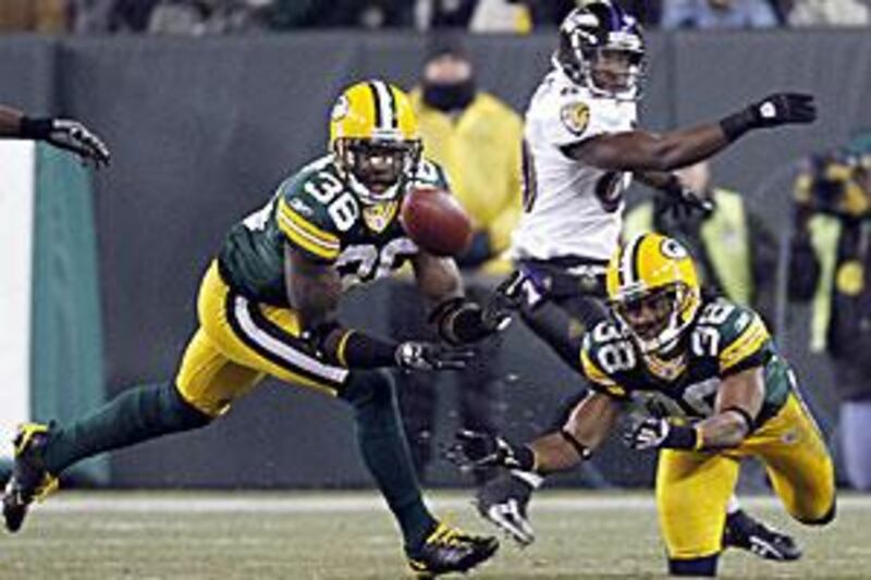 The Green Bay Packers' Nick Collins, No 36, intercepts a pass intended for the Baltimore Ravens' Mark Clayton, No 89, in front of teammate Tramon Williams.