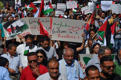 Protesters wave signs and Palestinian flags at an anti-Israel demonstration in Tunis on Thursday. AFP