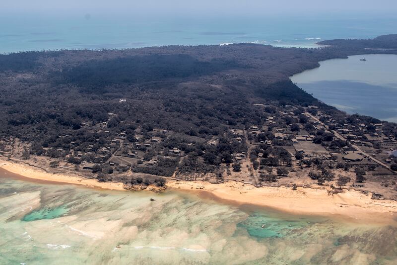 Volcanic ash covers roof tops and vegetation in an area of Tonga on January 17, days after a huge undersea volcanic eruption and tsunami struck. AP