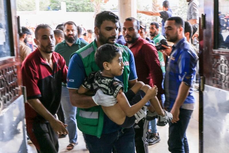 A medic carries a Palestinian child injured during Israeli air strikes into a hospital in Khan Yunis in the southern Gaza Strip. AFP