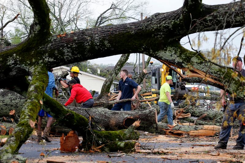 Volunteers help police and firefighters to clear trees in Sherwood, Arkansas. AP