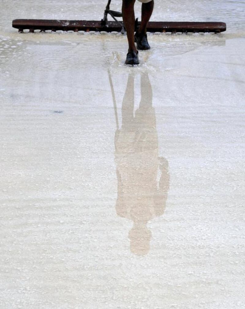 An Indian labourer collects salt at a salt pan on the outskirts of Mumbai. While the development of unused salt pan land is being viewed as a possible answer to the city’s staggering housing problem, real estate dealers feel that redevelopment of government-owned salt pans could get delayed for decades unless the private sector is allowed to participate. Indranil Mukherjee / AFP