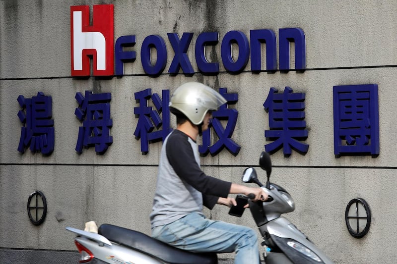 A motorcyclist rides past the logo of Foxconn, the trading name of Hon Hai Precision Industry, in Taipei, Taiwan March 30, 2018. REUTERS/Tyrone Siu