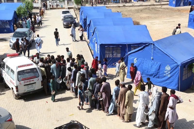 Displaced people join a food queue at a tent city set up by the Government of Sindh, Hyderabad. EPA
