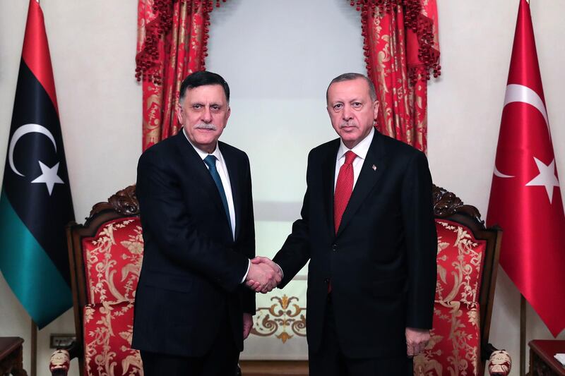 A handout picture taken and released on November 27, 2019, by the Turkish Presidential Press service shows Turkish President Recep Tayyip Erdogan (R) shaking hands with Fayez al-Sarraj (L), the head of the Tripoli-based Government of National Accord (GNA), during their meeting in Istanbul. - Turkey signed a military deal late on November 27, 2019, with Libya's UN-recognised government following a meeting with Turkish President in Istanbul, his office said. (Photo by Mustafa Kamaci / TURKISH PRESIDENTIAL PRESS SERVICE / AFP) / RESTRICTED TO EDITORIAL USE - MANDATORY CREDIT "AFP PHOTO / TURKISH PRESIDENTIAL PRESS SERVICE" - NO MARKETING - NO ADVERTISING CAMPAIGNS - DISTRIBUTED AS A SERVICE TO CLIENTS