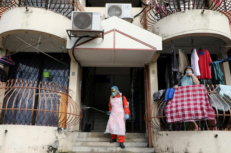 A worker sprays disinfectant at an apartment, amid the coronavirus disease outbreak in Kuala Lumpur, Malaysia. Reuters