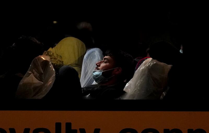A man sleeps on a bus after arriving in Dover.