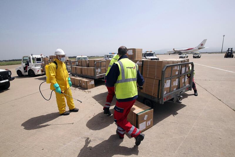 Workers unload medical supplies from China at Houari Boumediene International Airport in Algiers, Algeria, April 15, 2020. The equipment was donated to Algeria amid the ongoing coronavirus pandemic. EPA