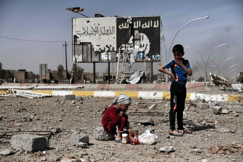 -- AFP PICTURES OF THE YEAR 2017 --

Iraqi children sit amidst the rubble of a street in Mosul's Nablus neighbourhood infront of a billboard bearing the logo of the Islamic State (IS) group on March 12, 2017, during an offensive by security forces to retake the western parts of the city from IS fighters. / AFP PHOTO / ARIS MESSINIS