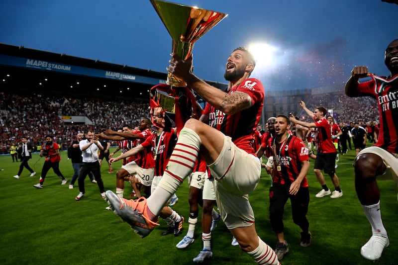 Olivier Giroud celebrates with the trophy after AC Milan won the Serie A title, in May, 2022. Reuters