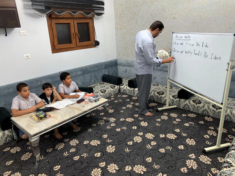 A man teaches his sons and nephews at home amid the coronavirus disease (COVID-19), in Misrata, Libya. REUTERS