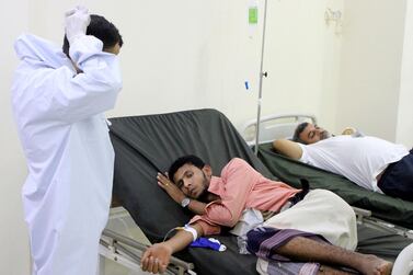 A Yemeni doctor dons a face mask as he talks to patients at a hospital in Aden. AP Photo