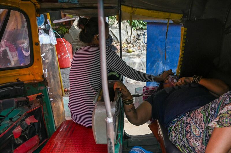 A Covid-19 coronavirus patient breathes with the help of oxygen provided by a Gurdwara, a place of worship for Sikhs, along the roadside in Ghaziabad in India. AFP