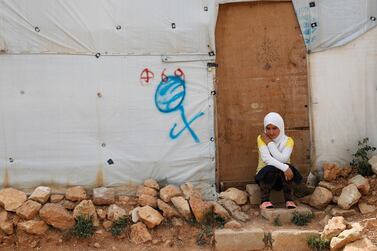 A Syrian refugee girl sits outside her tent, at an informal refugee camp, in Arsal, east Lebanony. Hussein Malla / AP Photo