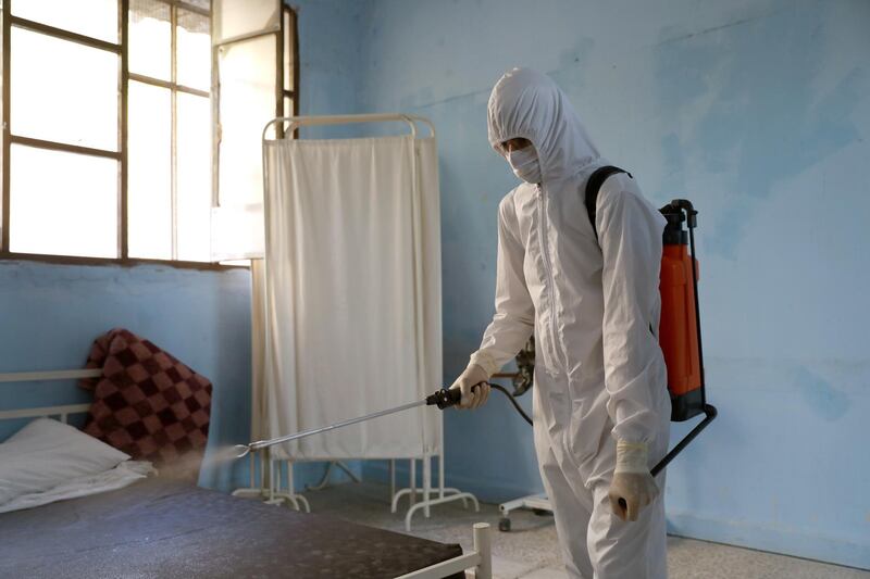 Medical personnel spray disinfectants at a community treatment centre for possible Covid-19 patients in Ariha city, south Idlib, Syria. EPA