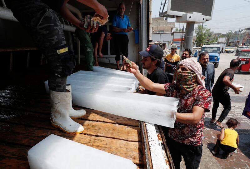 Iraqis buy ice blocks at a factory in Sadr City, east of the capital Baghdad, amid power outages and soaring temperatures.