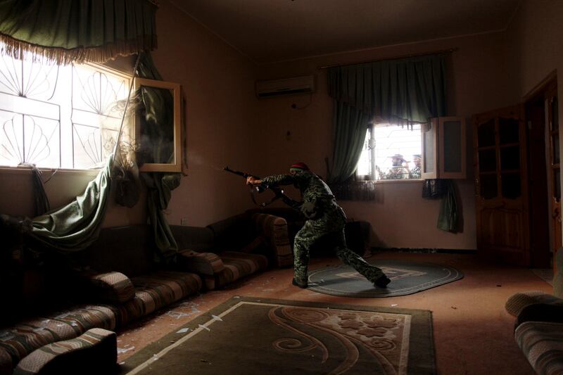 A Libyan rebel fighter fires his machine gun toward loyalist positions in Sirte, Libya, Wednesday, Oct. 19, 2011. Libyan revolutionary forces fought building by building against the final pocket of resistance in Moammar Gadhafi's hometown, the last major city in Libya to have been under the control of forces loyal to the fugitive leader. (AP Photo/Manu Brado) *** Local Caption ***  Mideast Libya.JPEG-08161.jpg