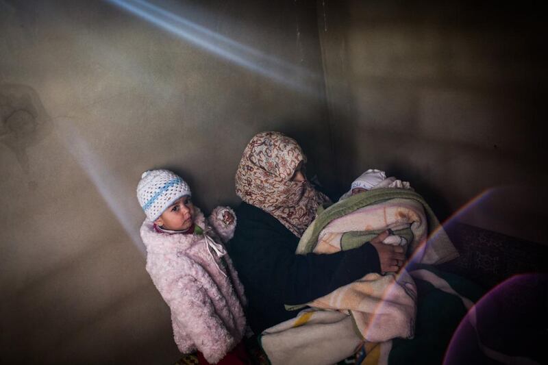 Syrian refugee Dalil, 20, with her one -year-old Rima and 6 week-old baby Fatima, at a rented house in Arsal, Lebanon.  A McConnell / UNHCR / December 15, 2013