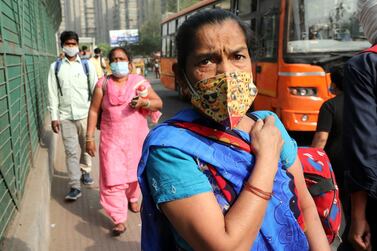 People arrive to board a bus in New Delhi, India. EPA