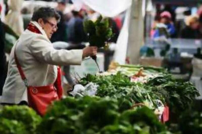 A customer selects produce at an organic fruit and vegetable market in Sydney.