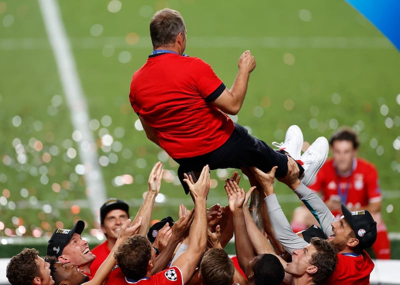 Bayern players lift coach Hansi Flick after the Champions League victory. AP