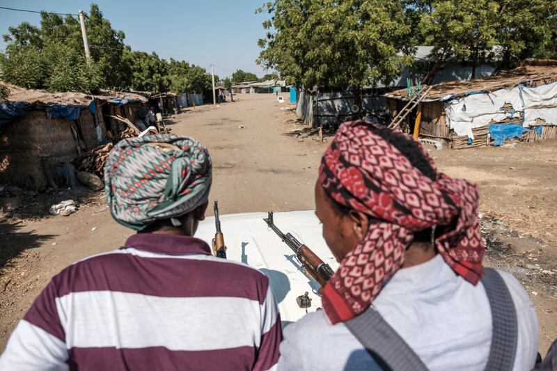 Two members of the Amhara militia ride in the back of a pick-up truck. Amharas and Tigrayans were uneasy neighbours before the current fighting, with tension over land sparking violent clashes.