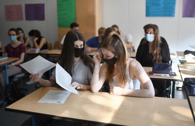 Students of the eleventh grade sit with face masks in a classroom of the Phoenix high school in Dortmund, western Germany, on August 12, 2020, amid the novel coronavirus COVID-19 pandemic. - Schools in the western federal state of North Rhine-Westphalia re-started under strict health guidelines after the summer holidays. (Photo by Ina FASSBENDER / AFP)