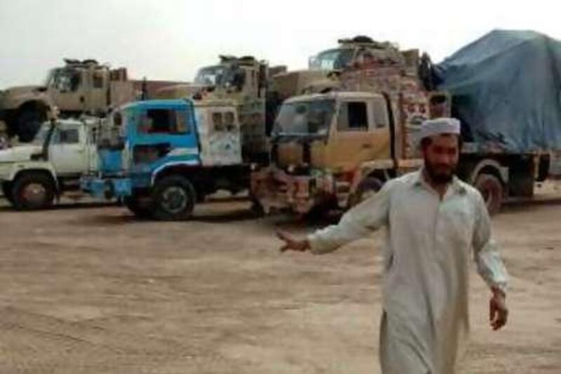 A man walks past trucks which are loaded with supplies for U.S. and NATO forces, in Peshawar, November 16, 2008. Pakistan will reopen a main supply route to Western forces in Afghanistan on Monday, a week after militants hijacked more than a dozen trucks on the road through the Khyber Pass, a senior official said on Sunday. REUTERS/Ali Imam (PAKISTAN) *** Local Caption ***  ISL03_PAKISTAN-KHYB_1116_11.JPG