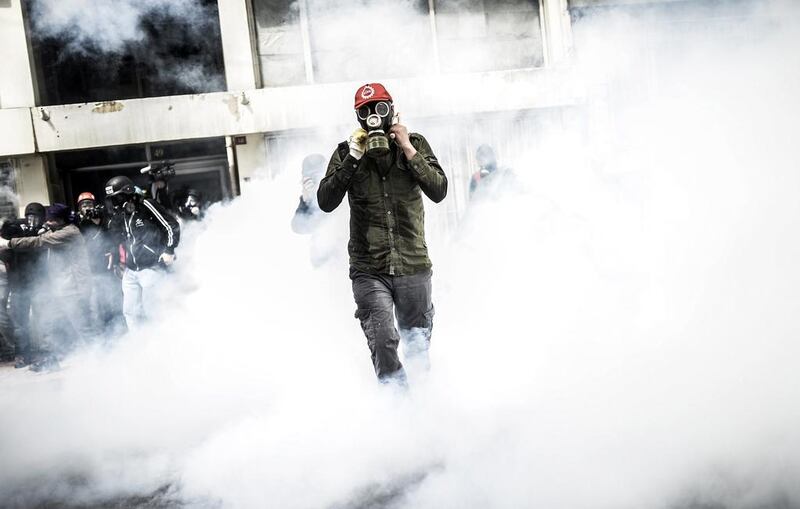 A Turkish protester wearing a gas mask stands amid a fog of tear gas that was fired by riot police to disperse a May Day rally near Taksim Square in Istanbul Turkish police used water canon and tear gas to disperse thousands of protesters who tried to defy a Labour Day ban on demonstrations in the Square. Bulent Kilic / AFP Photo
