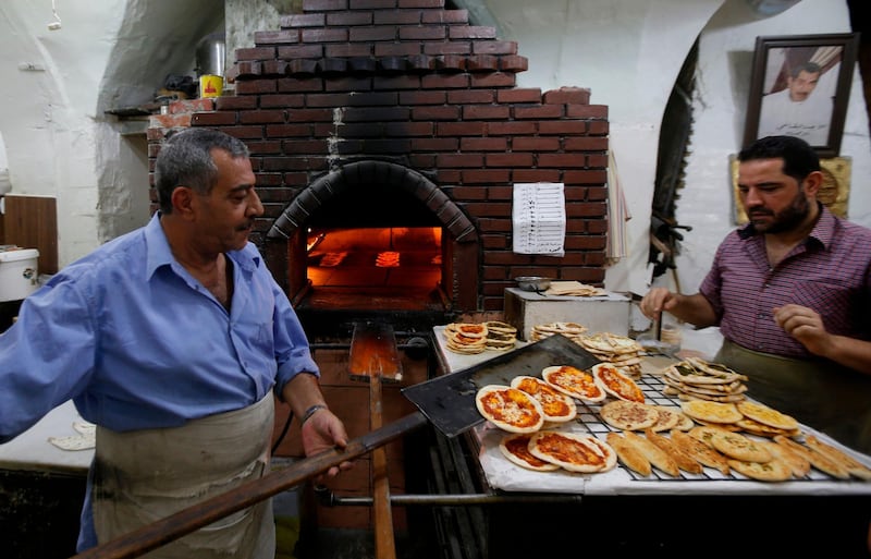 Syrian men work in their bakery in old Damascus. AFP