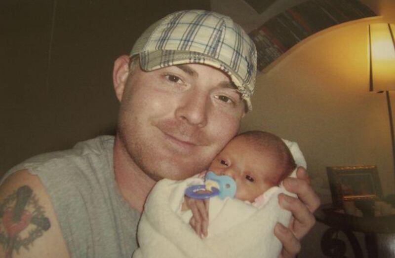 Michael Joslin, a Pennsylvania National Guardsman, who was arrested last month at Dubai airport on his way to Afghanistan, holds Mackenzie, his newborn daughter, in March.