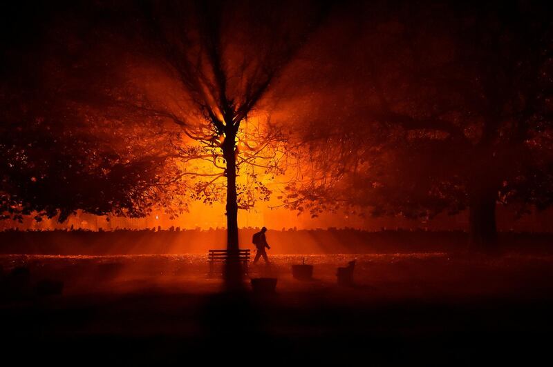 A man uses a torch to walk through a park during cold fog at night in Athboy, Ireland. REUTERS