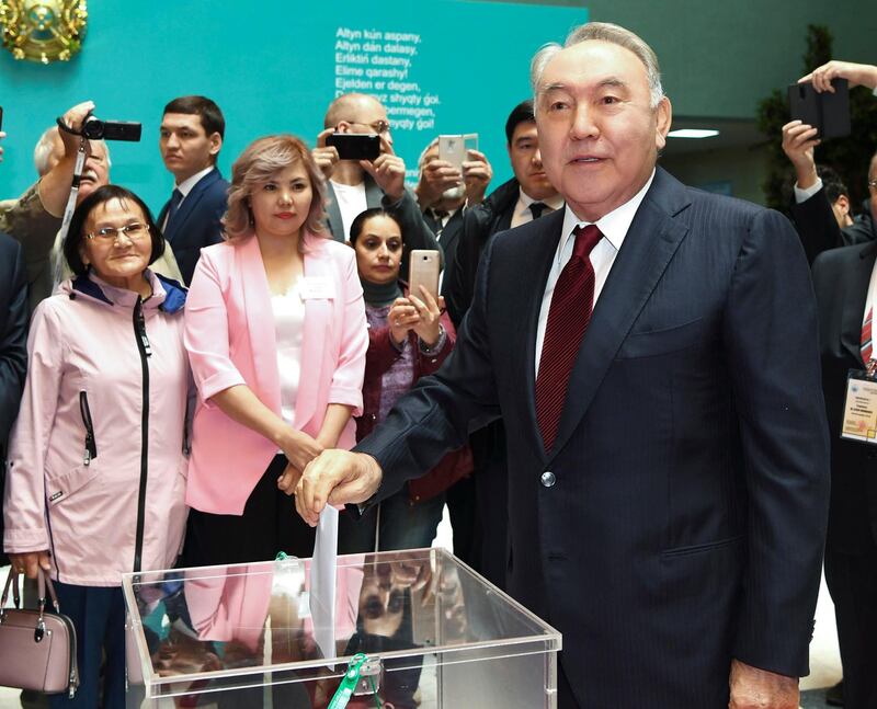 Former Kazakh President Nursultan Nazarbaye, right, casts his ballot at a polling station during the presidential elections in Nur-Sultan, the capital city of Kazakhstan, Sunday, June 9, 2019. Voters in Kazakhstan are choosing a successor to the president who had led the Central Asian country since independence from the Soviet Union, with a longtime loyalist expected to win easily. (Kazakhstan's Presidential Press Office via AP)