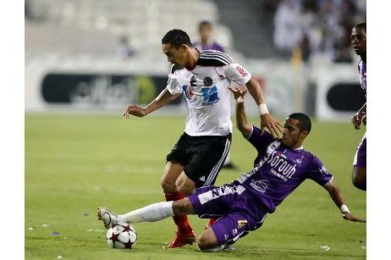 Al Jazira's Ricardo Oliveira, in white, is tackled in a match against Al Ain last season. Sammy Dallal / The National