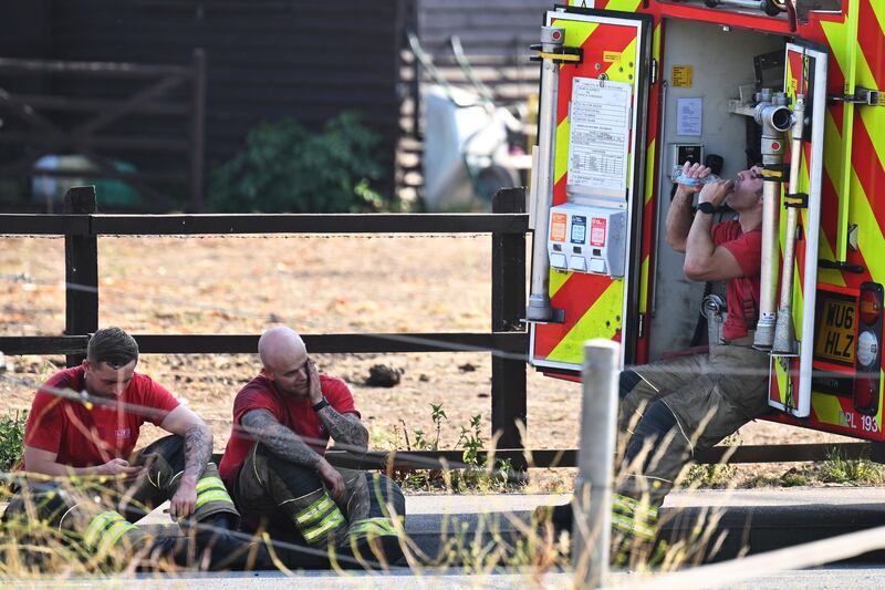 Firefighters rest after attending to fires in Wennington, England, in July 2022